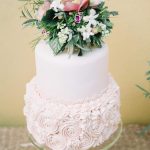 White wedding cake with flower topper