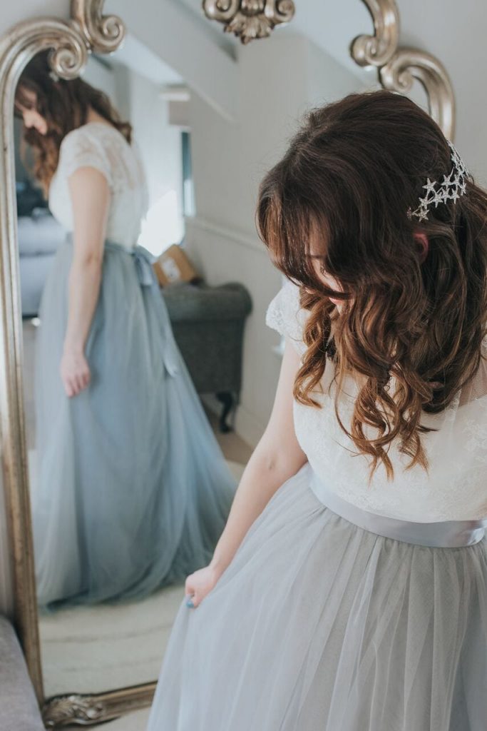 bride mirror shot of wedding dress with lace bodice and grey skirt