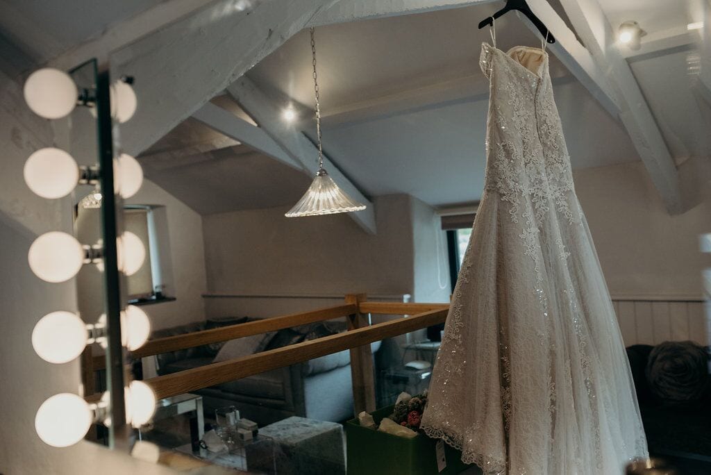 wedding dress hanging from ceiling beam with mirror lights in view 