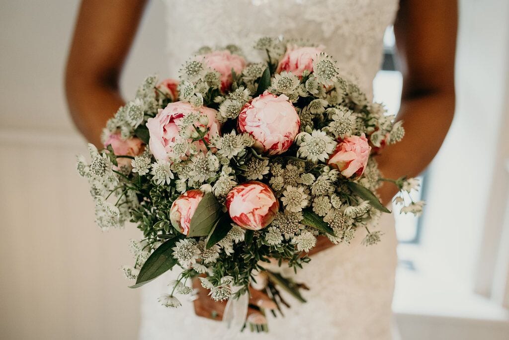 bride holding pink green and ivory bridal bouquet 