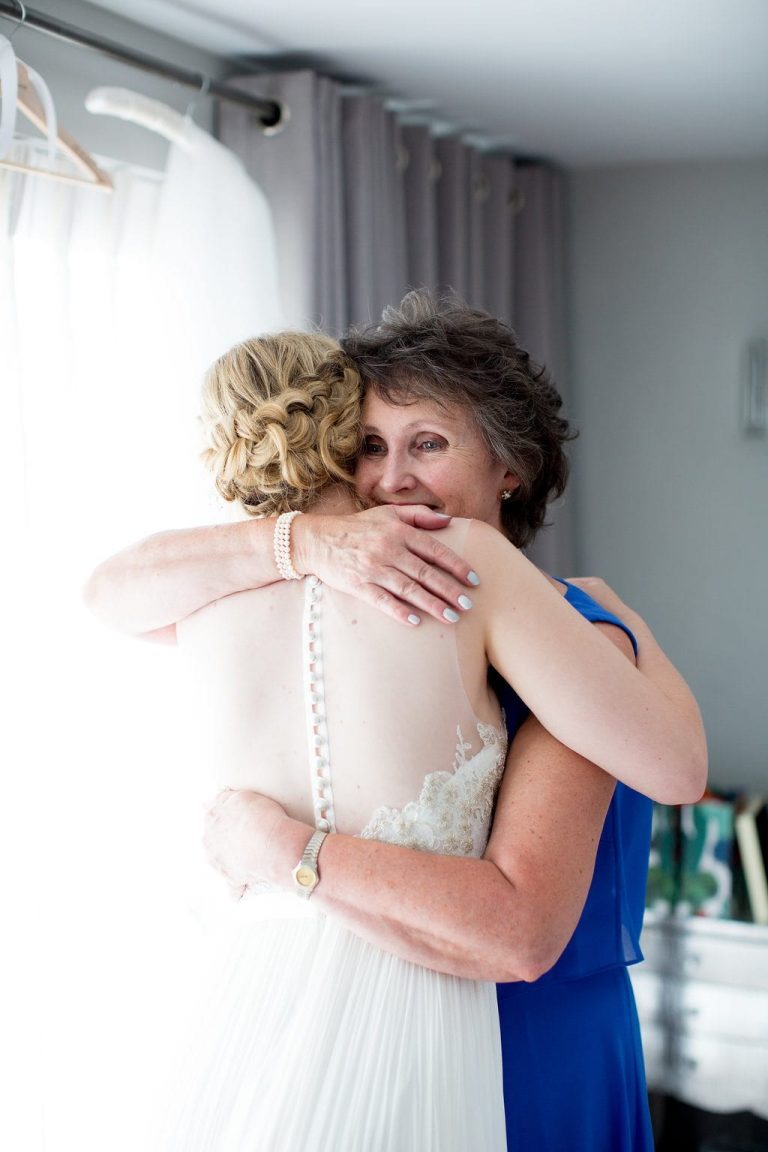 bride and mother of the bride embracing