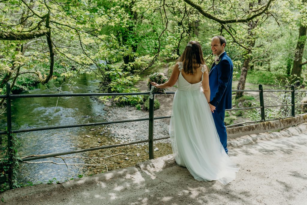 bride and groom on a bridge over a dartmoor river