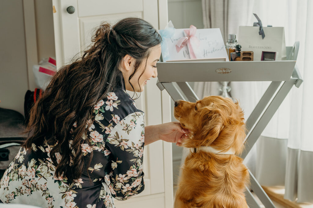 golden retriever dog looking at bride owner in front of butler's tray of wedding accessories