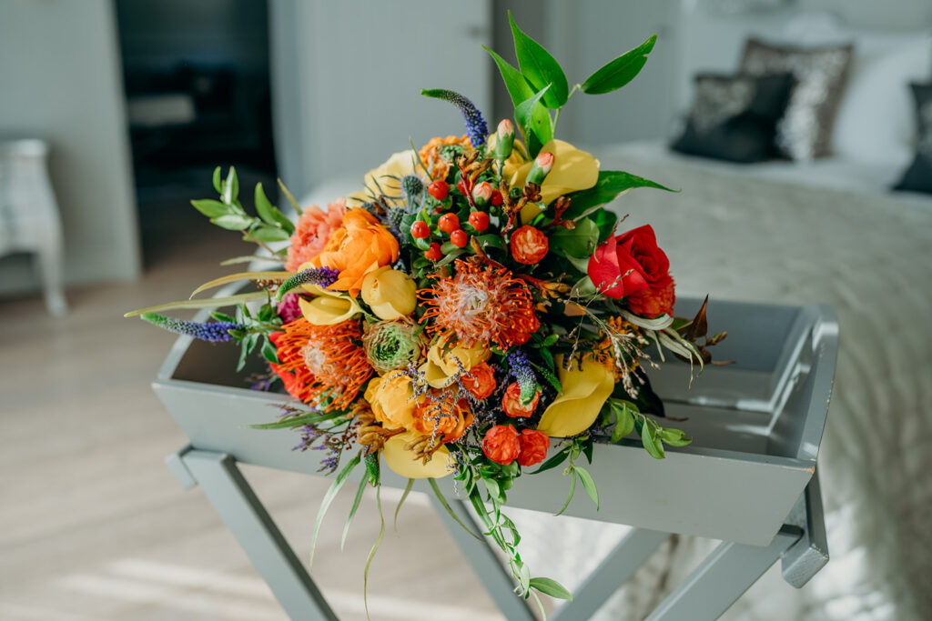 bright coloured bridal bouquet placed on grey painted butlers table