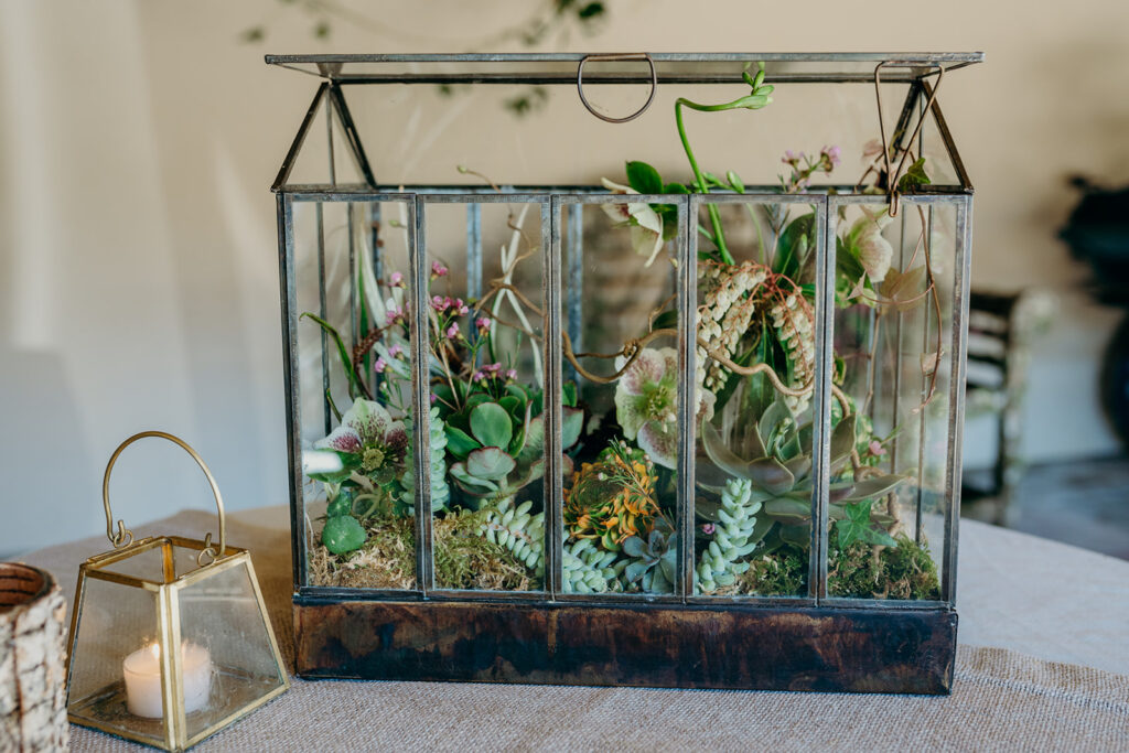 terrarium filled with succulent and spring flowers on a linen covered table