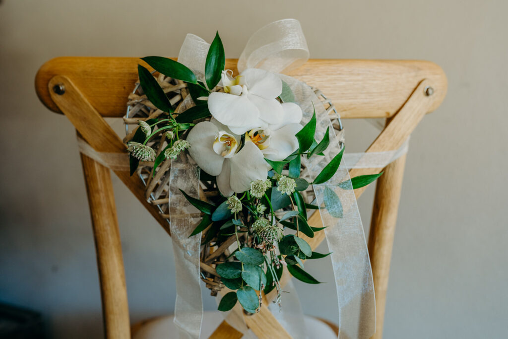 white orchid chair arrangement on bentwood wedding chair
