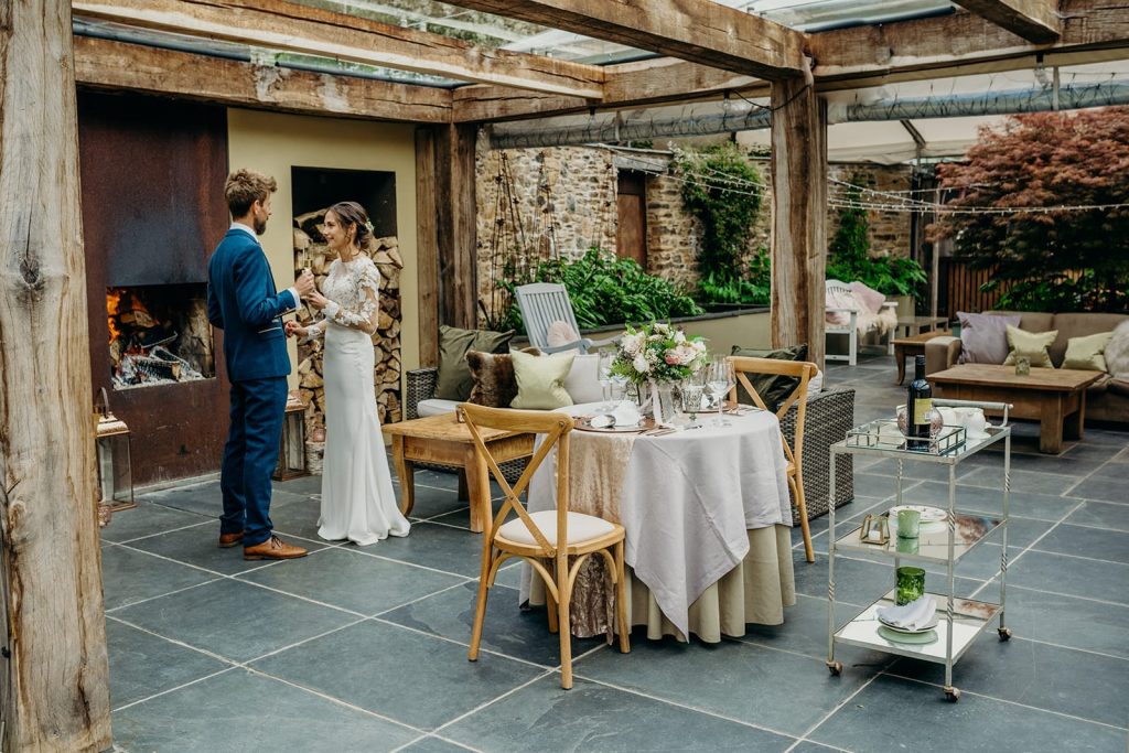 elope in May. Oak slate and stone glass roofed terrace set up for elopement wedding with bride and groom