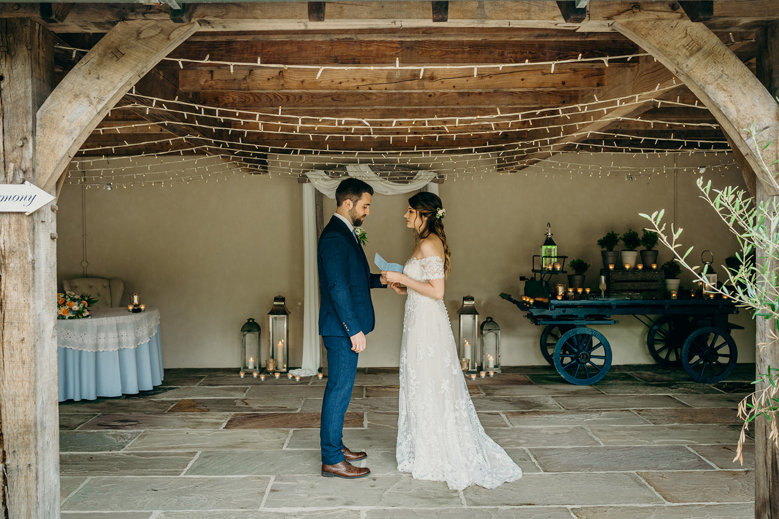 how to tell family and friends you're eloping. Elopement wedding with bride and groom in a rustic wedding barn reading wedding vows 