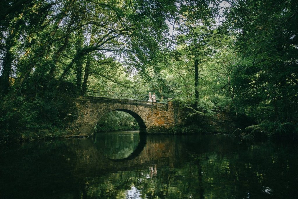 bride and groom on grenofen bridge dartmoor water reflection