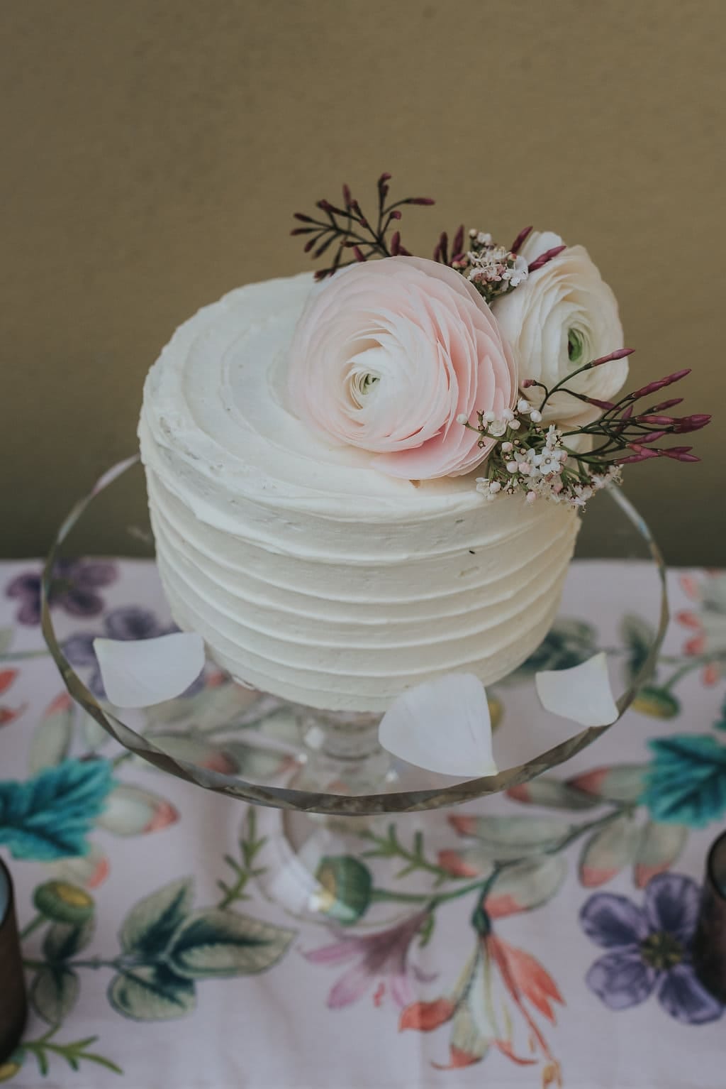 miniature elopement wedding cake with ivory buttercream icing decorated with blush pink flowers 