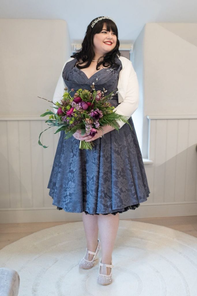 bride in her grey elopement wedding dress with bouquet 
