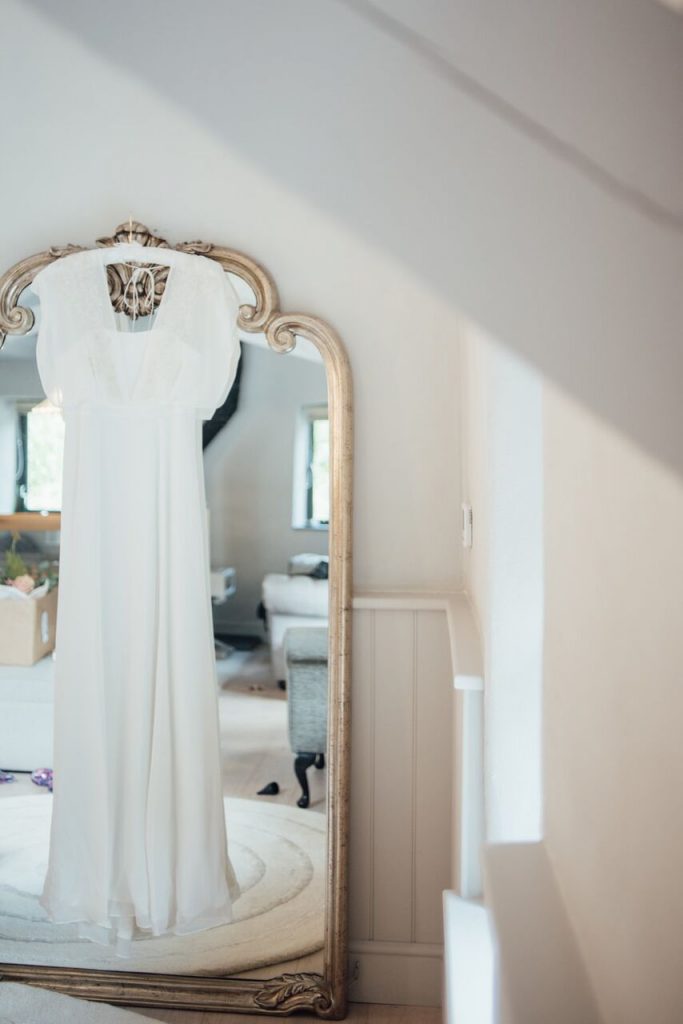 first elopement brides dress hanging by mirror