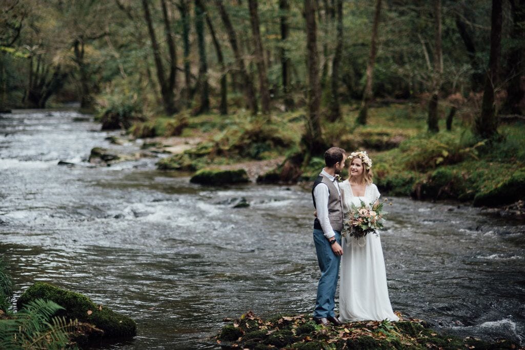 first elopement couple on rock in river 
