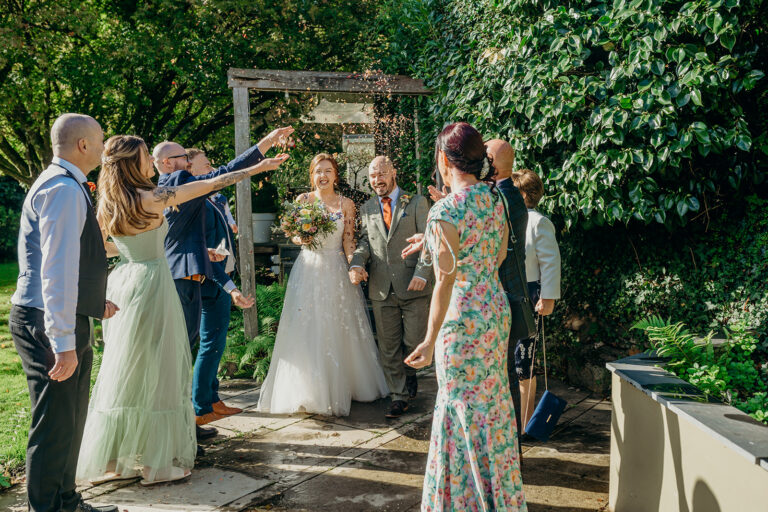 bride and groom walking through elopement confetti throw outdoors