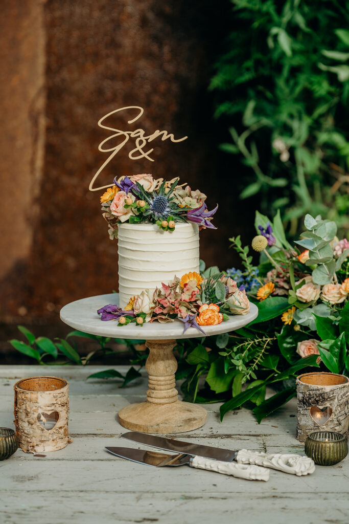 elopement wedding cake on marble and wood stand rustic backdrop