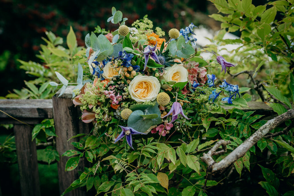 colourful bridal bouquet outdoors on wooden balastrade