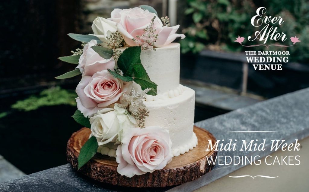 small wedding cake on log slice with blush pink roses