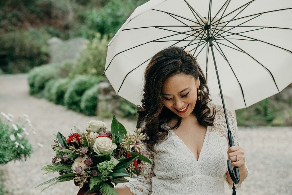 supreme style bride with bouquet under umbrella 