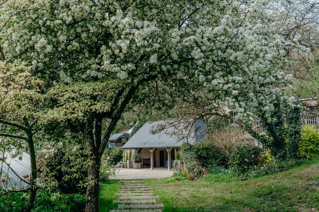 long view of a wedding barn through a blossom tree