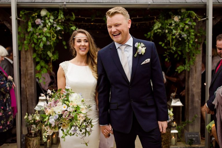 outdoor close up of bride & groom smiling after wedding ceremony large white bridal bouquet