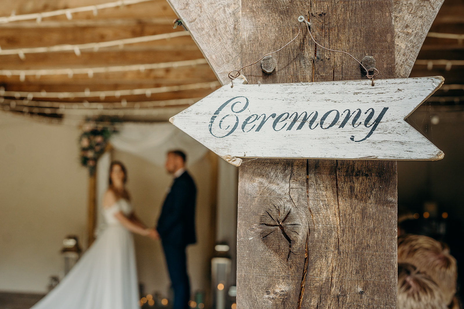 legal requirements for eloping - all you need to know. Rustic ceremony sign 'ceremony' pointing to bride and groom in the background in front of a ceremony arch