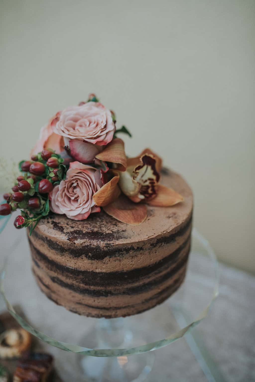 miniature elopement chocolate naked wedding cake with dusky pink flowers and burgundy berries