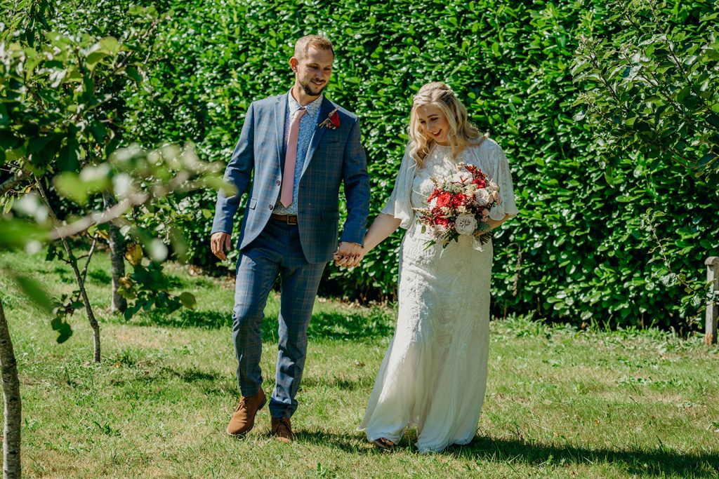 still photo from elopement wedding film bride and groom walking in a Devon orchard